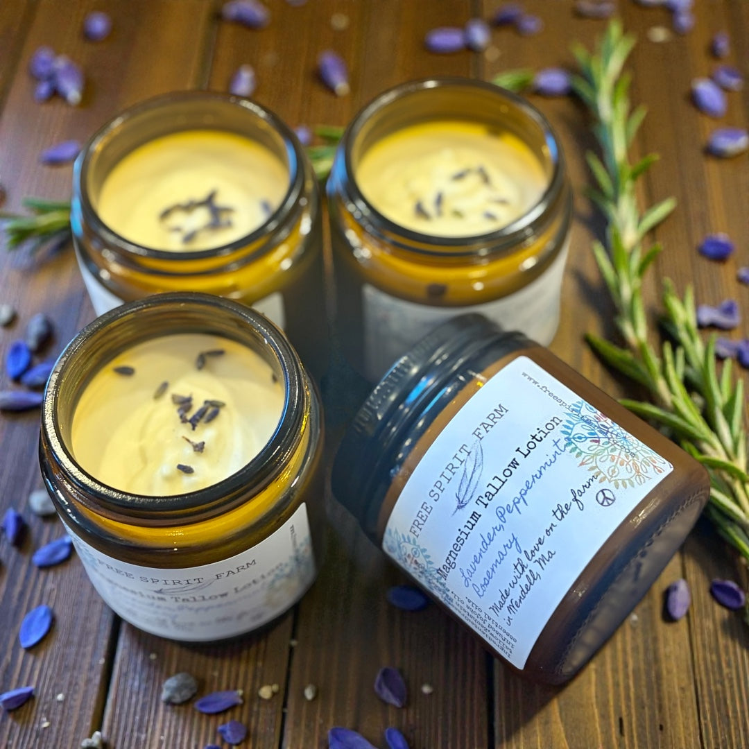 Three jars of Magnesium Tallow Lotion on a wooden surface with lavender flowers.