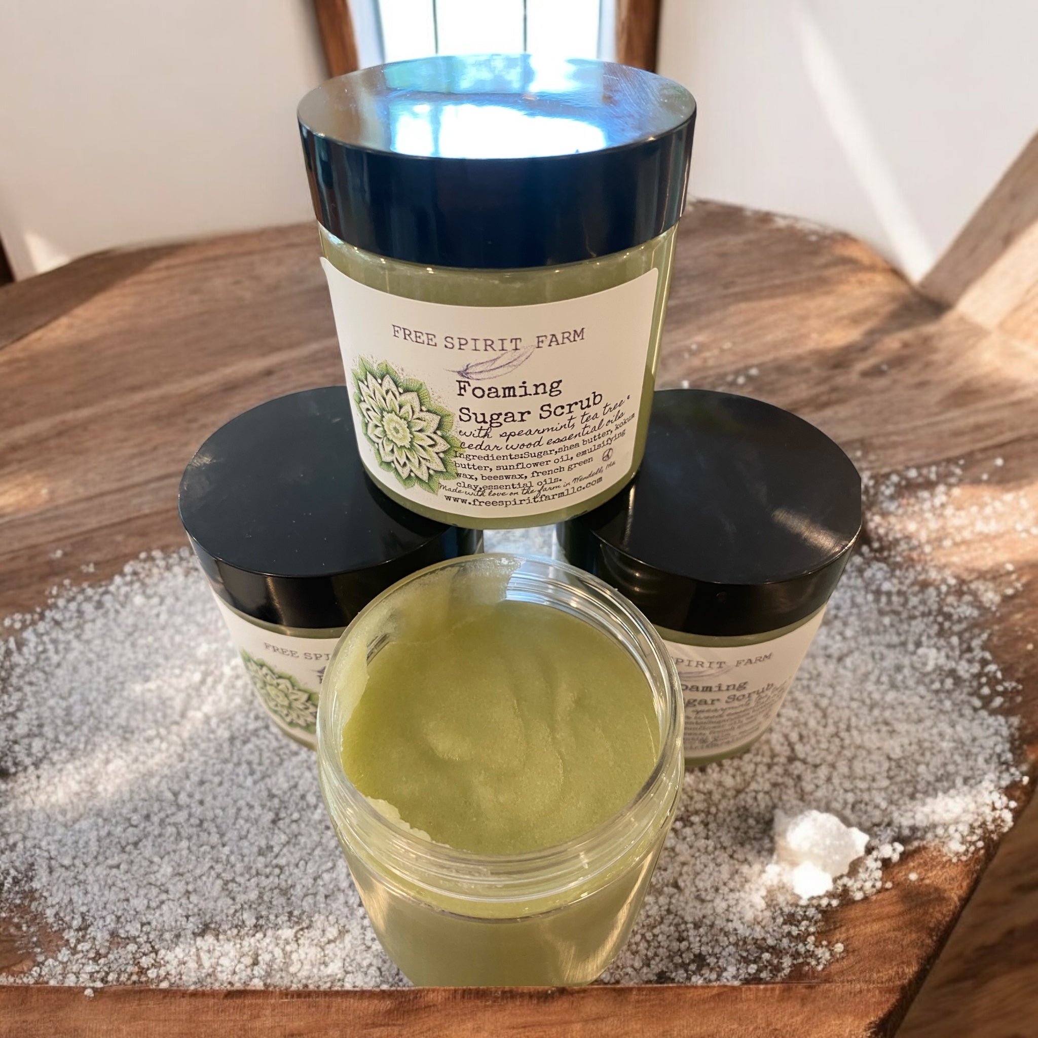 A container of Foaming Sugar Scrub with a label that reads &