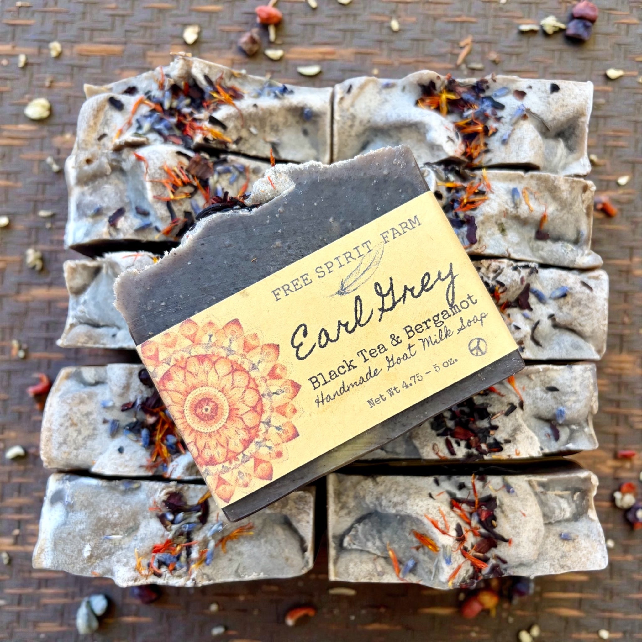 Bar of soap with a label on top of stacked soap bars on a wooden surface