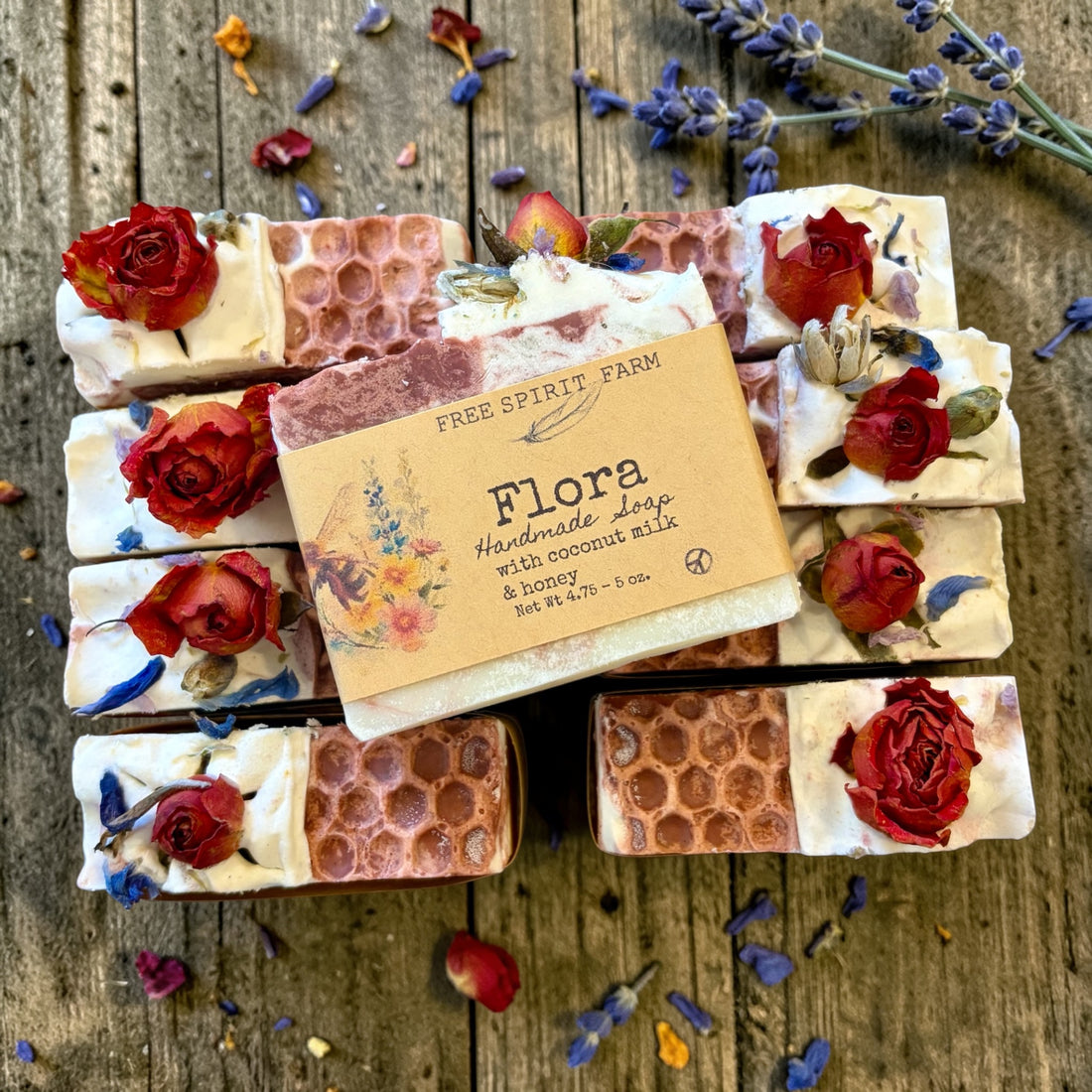 Handmade soap bars with floral decorations on a wooden surface, featuring a &