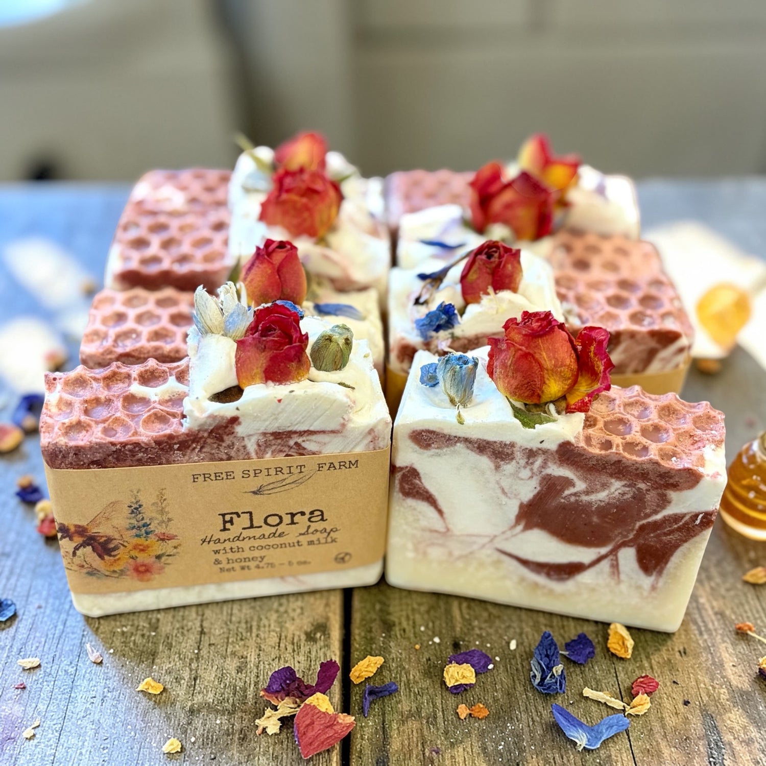 Handmade soap bars with floral decorations on a wooden surface