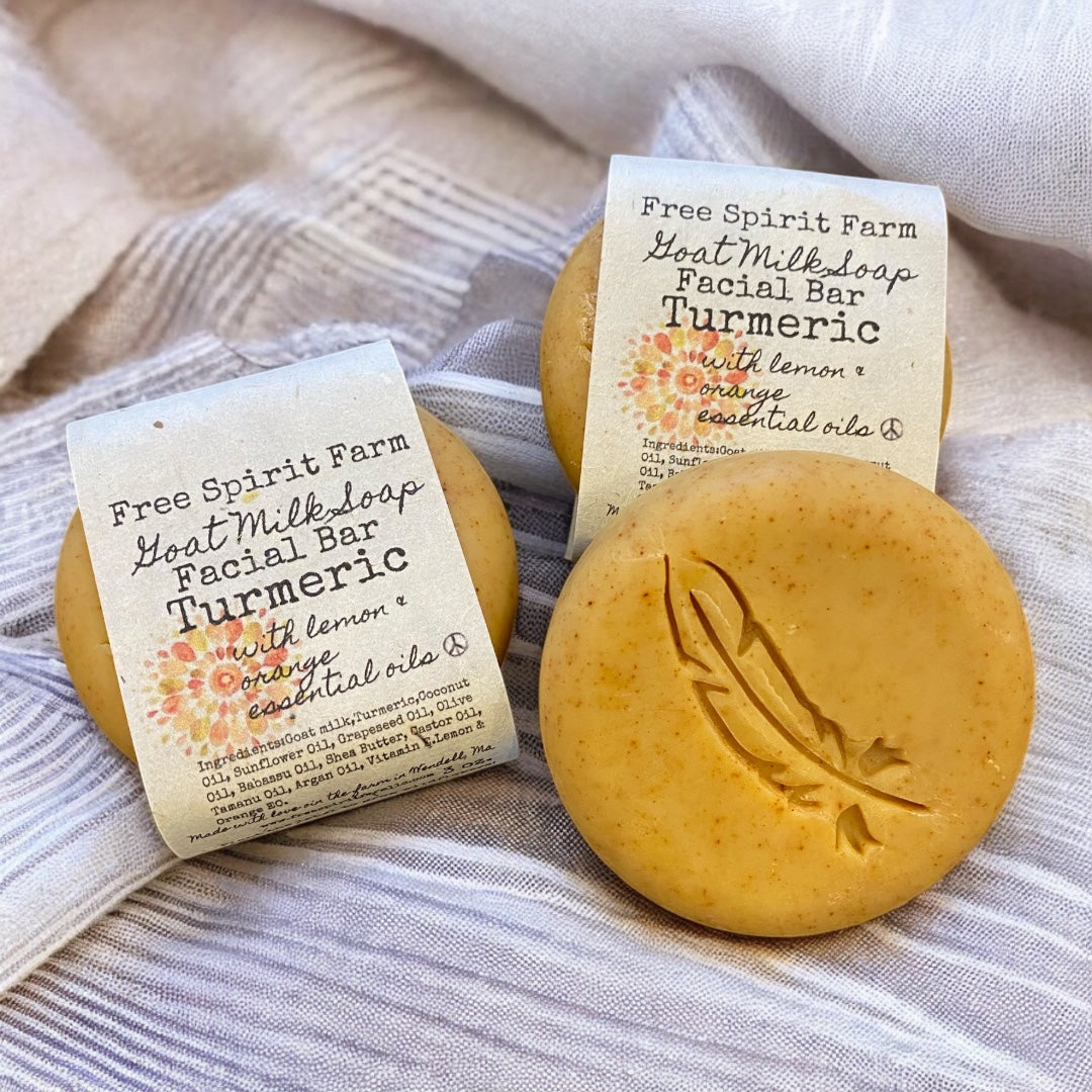 Handmade facial bars with turmeric, goat milk, lemon and orange essential oils by Free Spirit Farm. The bars are yellow with exfoliating properties and branded with labels.