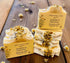 Two bars of soap with decorative elements on a wooden surface, featuring &