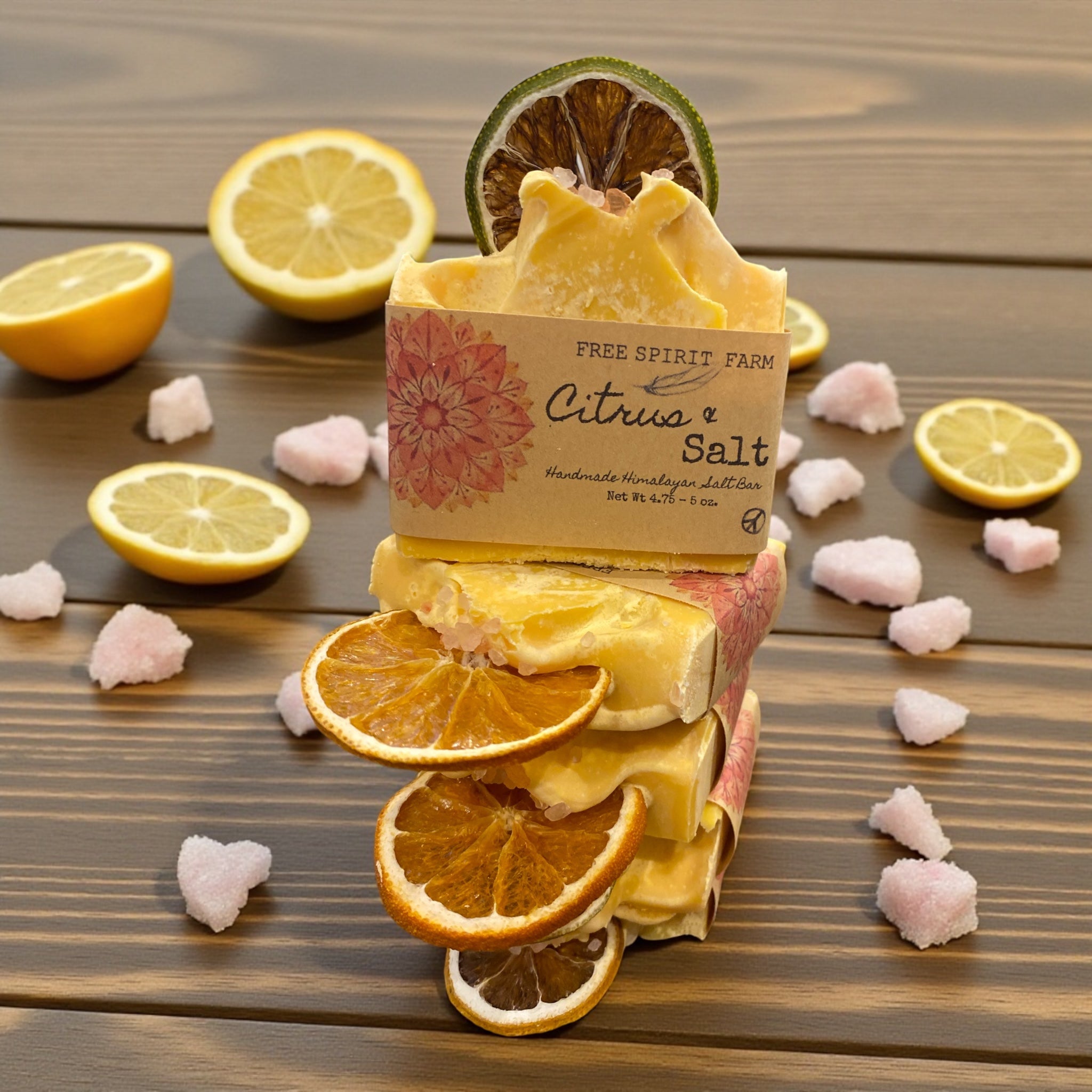 Bar of soap with citrus and salt fragrance on a wooden surface with lemons and oranges.