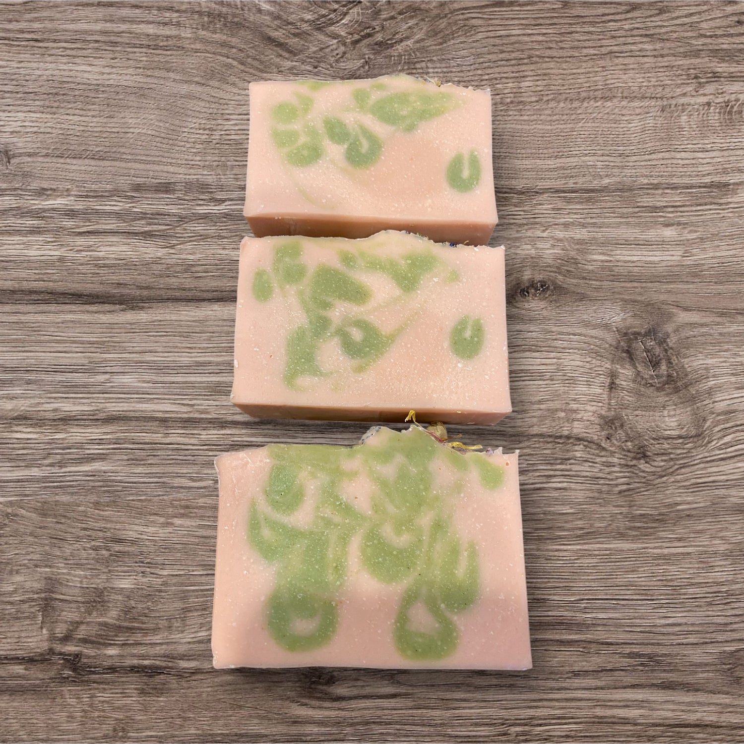 Goat milk soap bars with floral design on top, labeled &