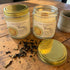 Two glass jars with gold lids labeled &