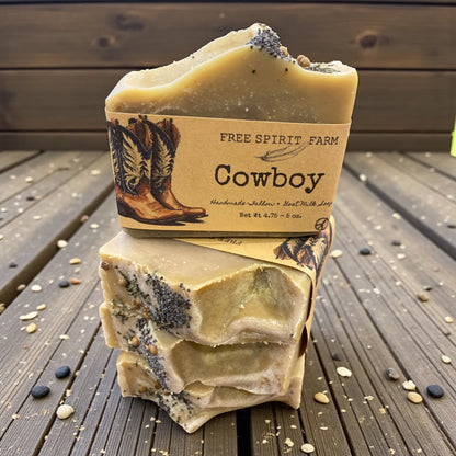 Stack of cowboy-themed soap bars with a label on a wooden surface