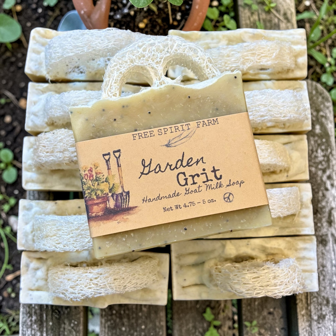 Stack of Garden Grit soap bars with a Free Spirit Farm label on a wooden surface.
