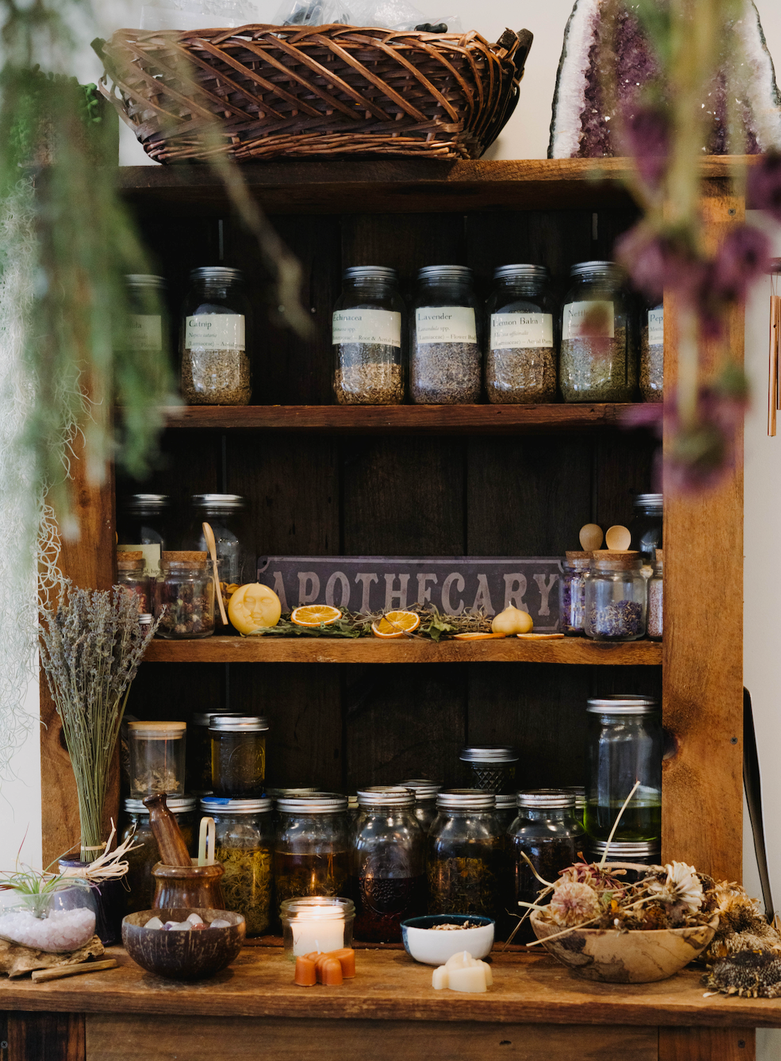 Wooden shelf with various jars and herbs in a rustic setting
