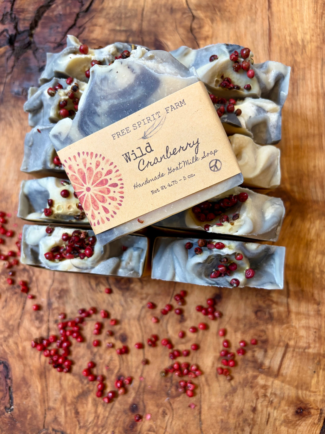 Wild Cranberry and  Free Spirit Farm are arranged on a wooden surface with scattered cranberries.