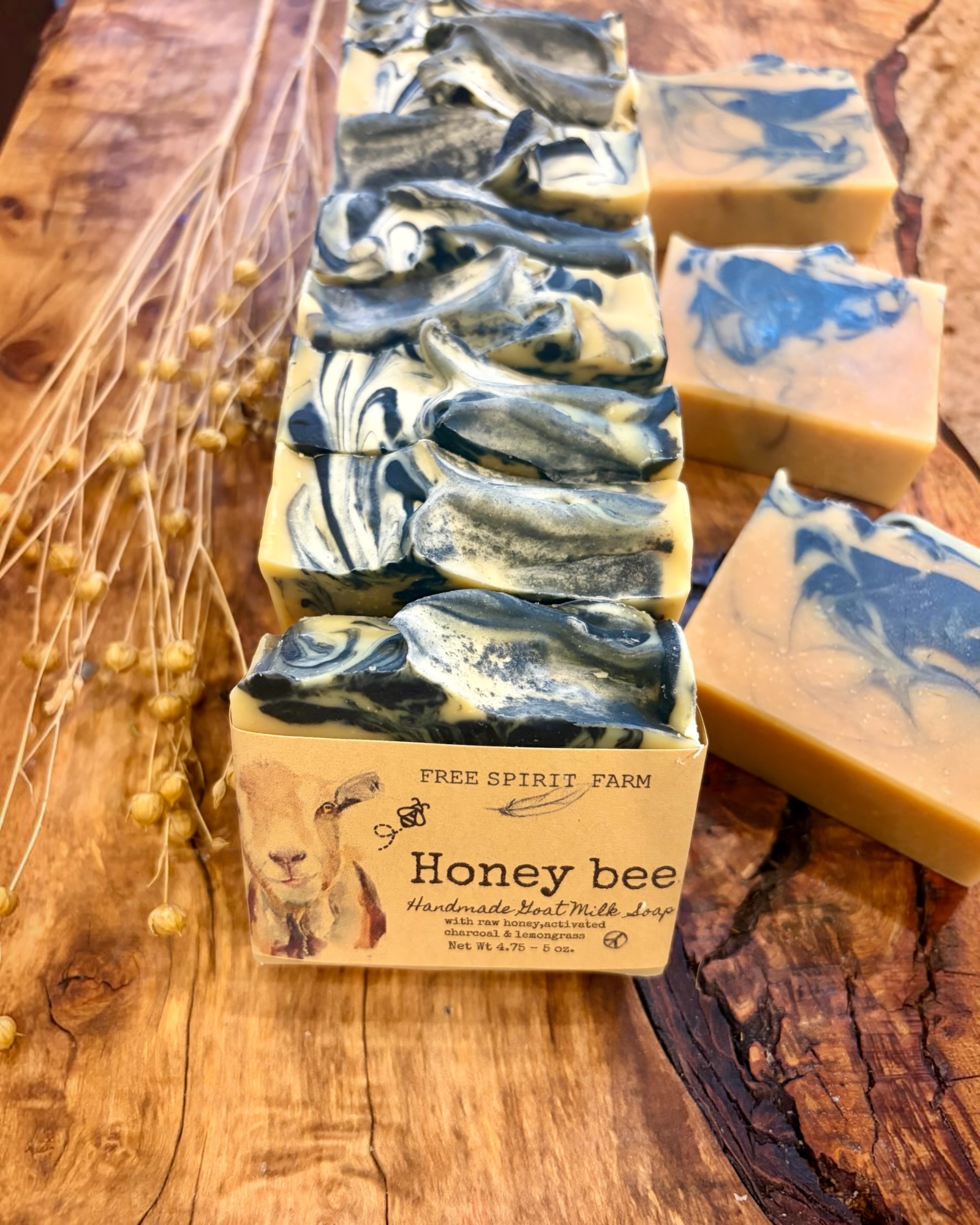 Handmade Free Spirit Farm soap bars with honey bee design on a wooden surface