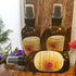 Three bottles of Free Spirit Farm Leave In Conditioner on a wooden surface with flowers in the background.