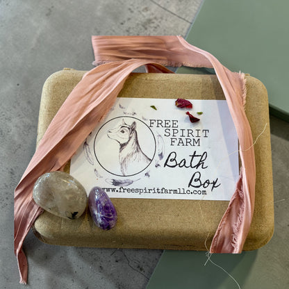 Bath box with pink ribbon and stones on a concrete surface, featuring Free Spirit Farm branding.