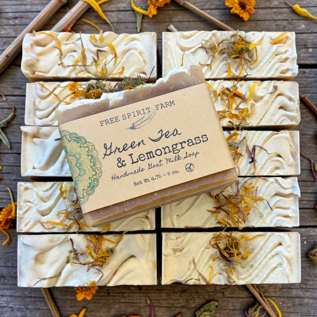 Handmade soap bars with green tea and lemongrass scent on a wooden surface.