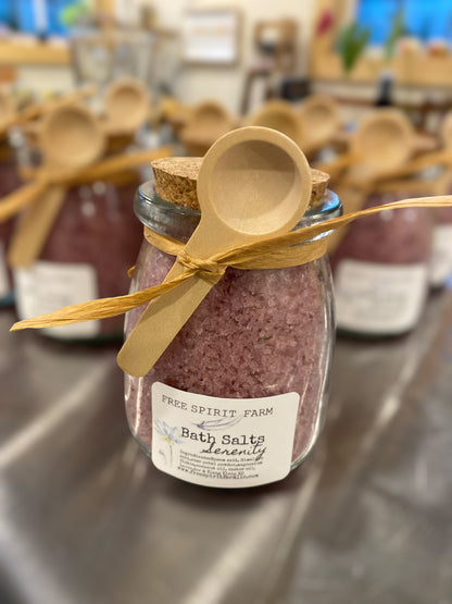 Jar of bath salts with a wooden spoon on a metal surface, labeled &