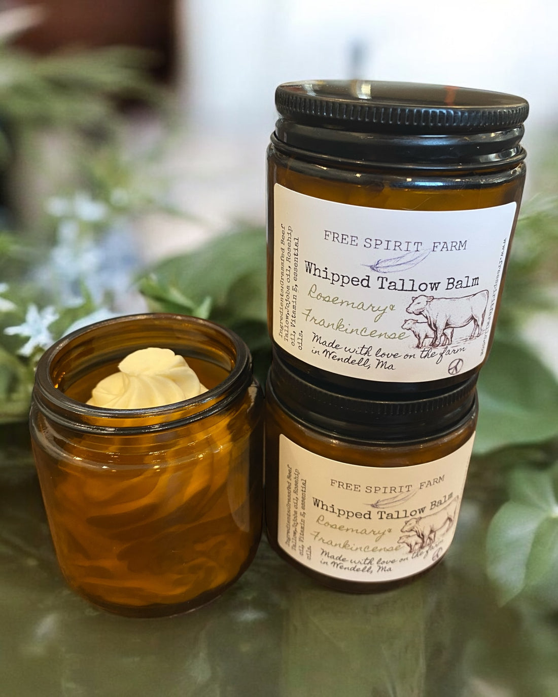 Two jars of whipped tallow balm, one open with product visible, the other closed with label reading &