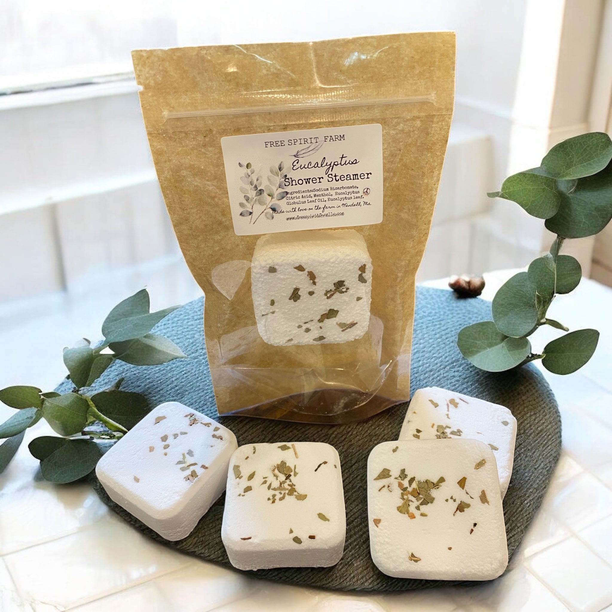 Packaged shower steamer with eucalyptus on a dark surface with greenery