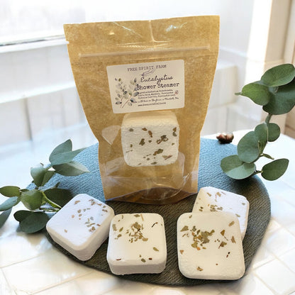 Packaged shower steamer with eucalyptus on a dark surface with greenery