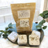 Packaged shower steamer with eucalyptus on a dark surface with greenery