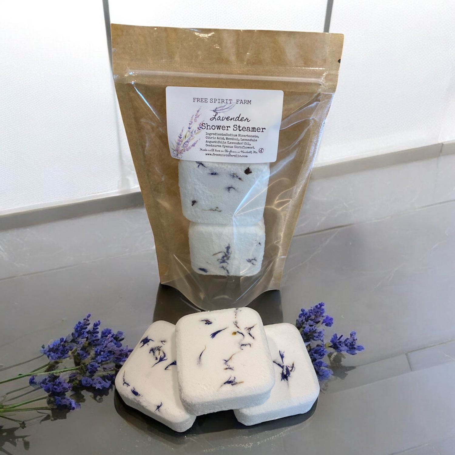 Lavender shower steamers with packaging on a white surface