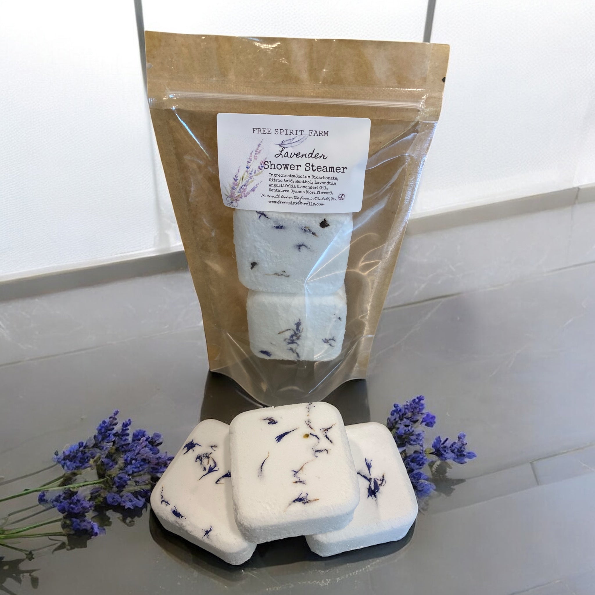Lavender shower steamers with packaging on a white surface