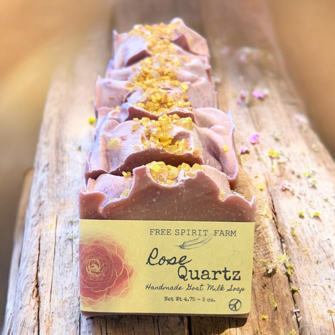 Bar of soap with rose quartz crystals on a wooden surface, labeled &