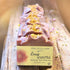 Bar of soap with rose quartz crystals on a wooden surface, labeled &