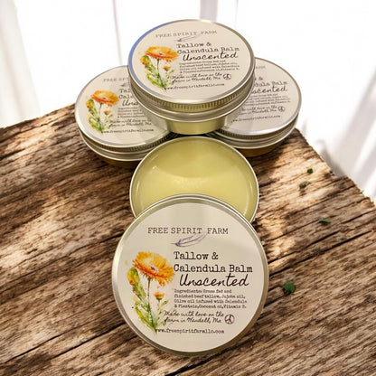 Tallow and calendula balm tins on a wooden surface with &
