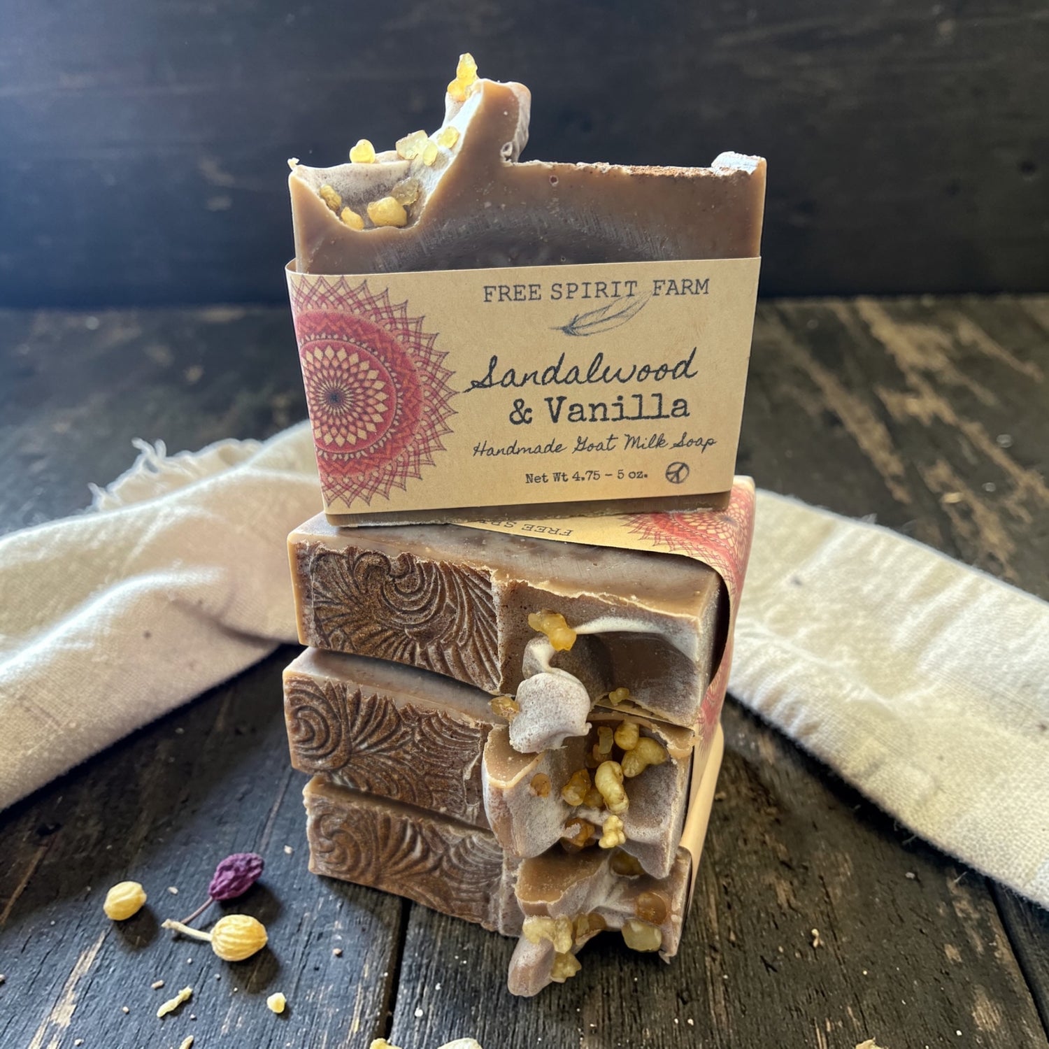 Stack of handmade soap bars with a Free Spirit Farm label on a wooden surface