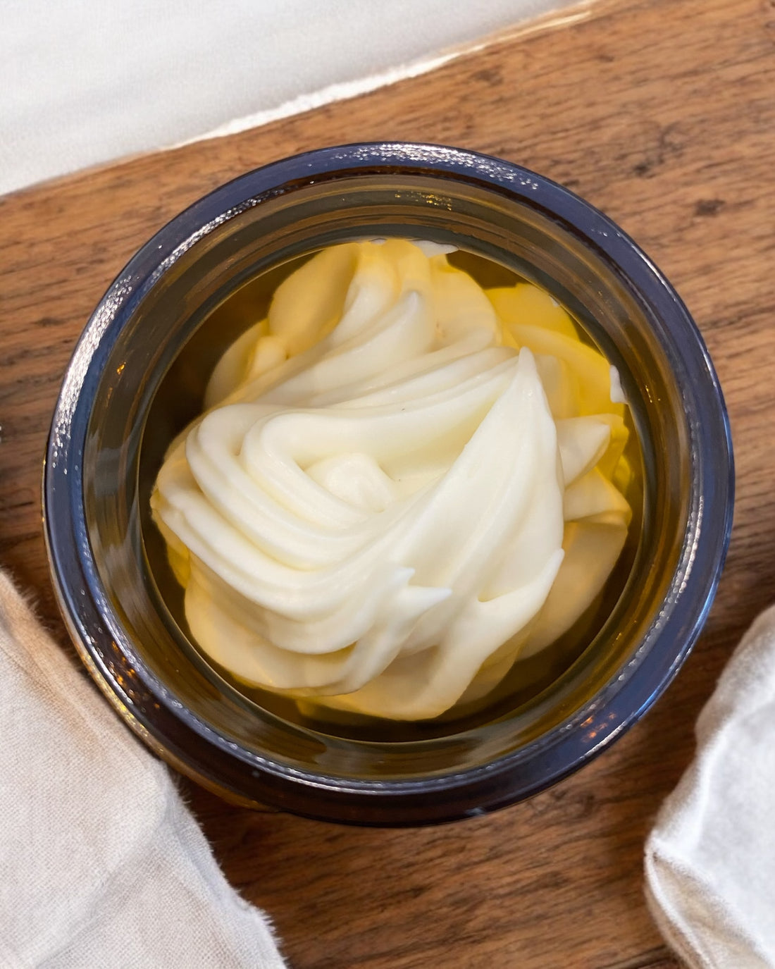 Jar of whipped tallow balm, one open with product visible, the other closed with label reading &