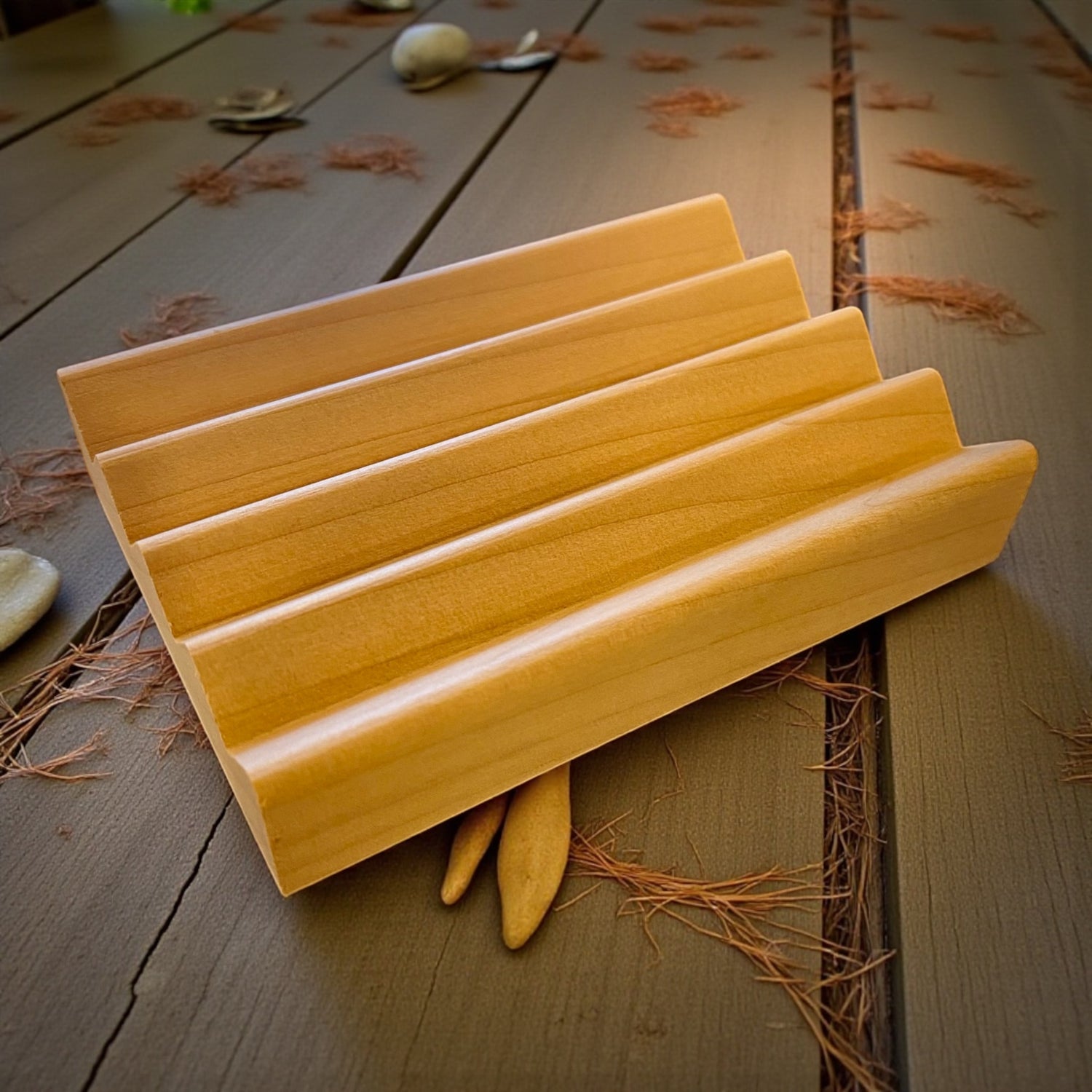 Wooden soap dish on a rustic wooden surface with leaves
