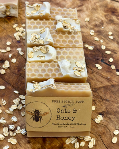 Stack of oats and honey soap bars with a visible free spirit farm brand label on a wooden surface.
