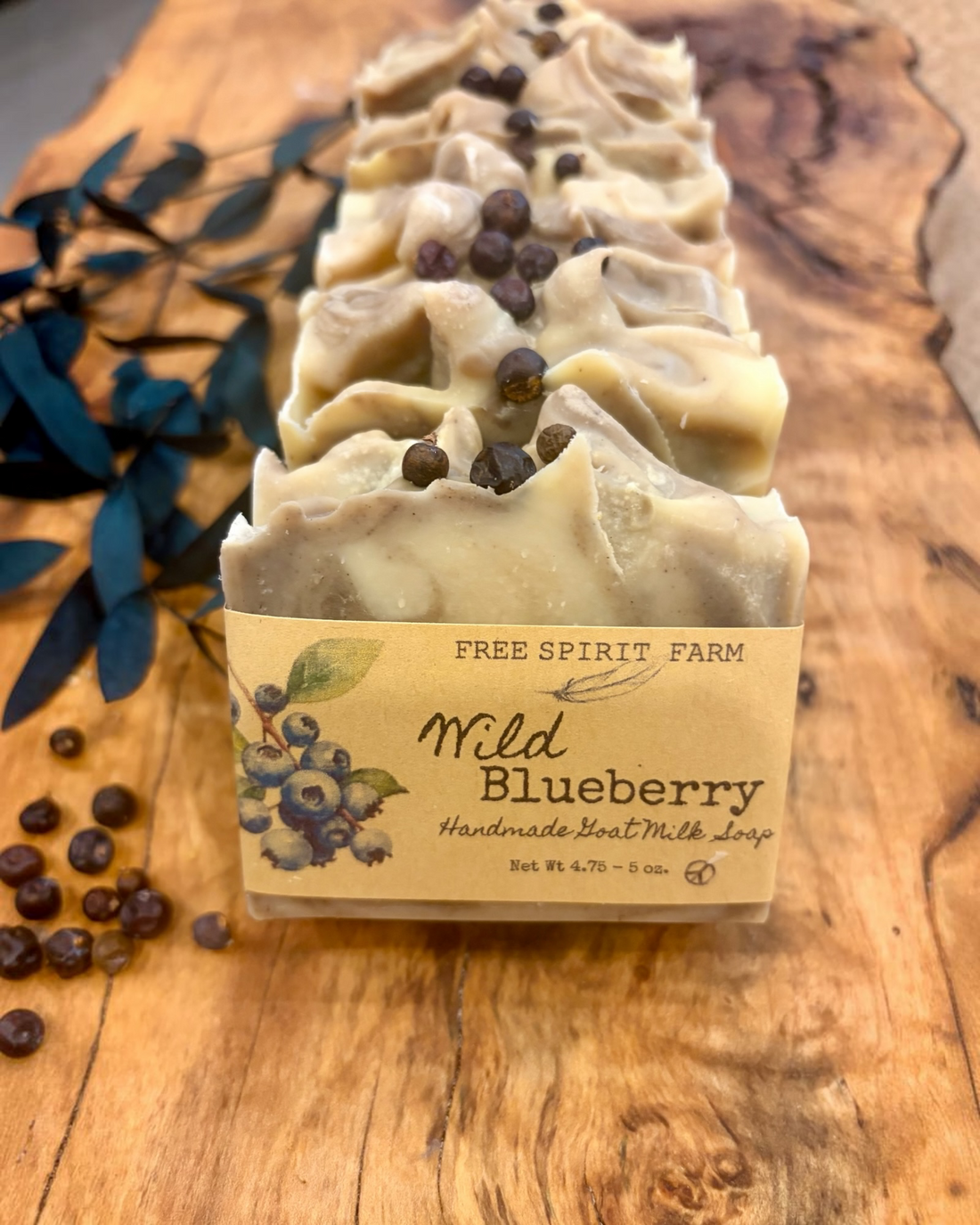 A row of handmade soap bars wrapped in paper sleeves, labeled &