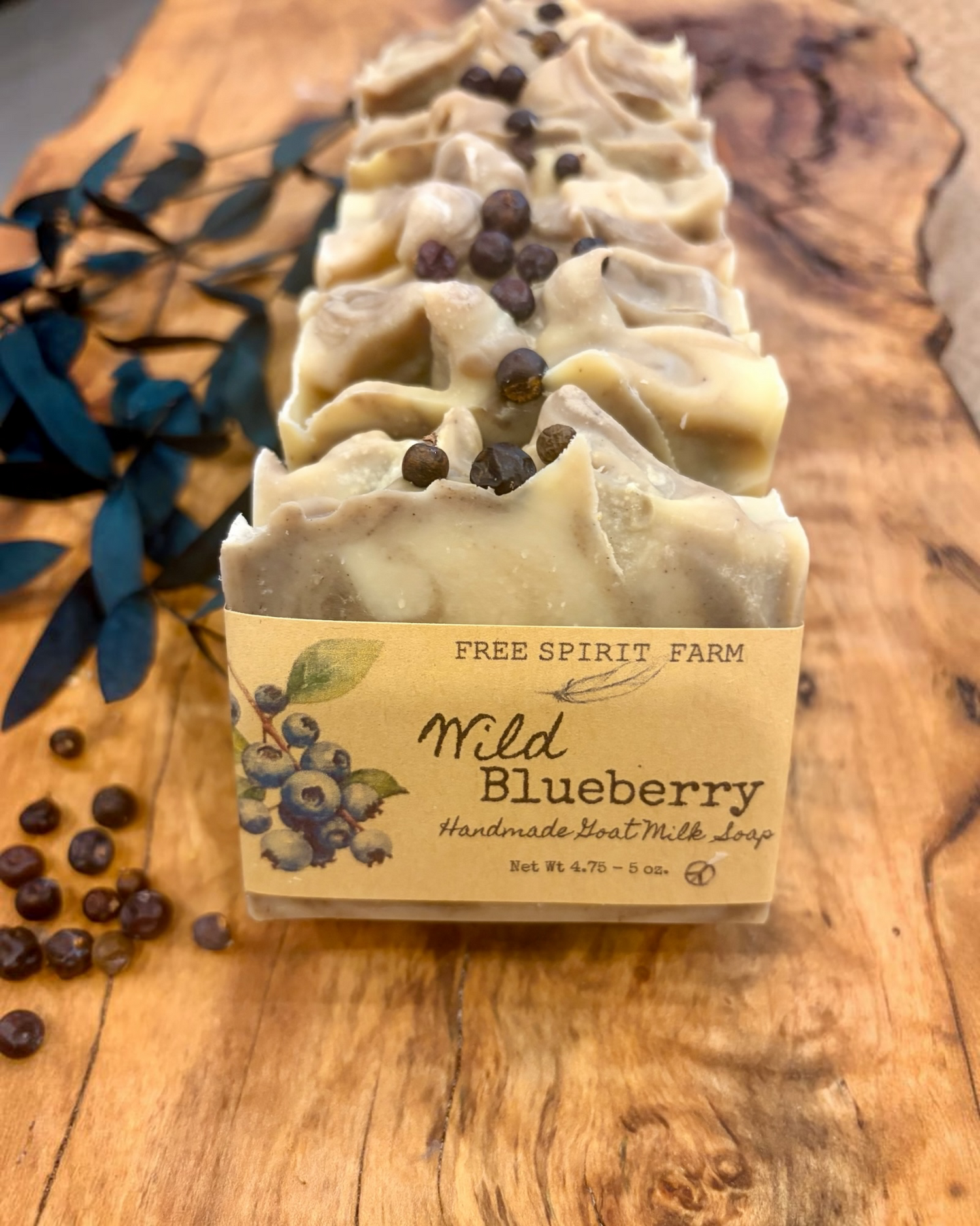 A row of handmade soap bars wrapped in paper sleeves, labeled &